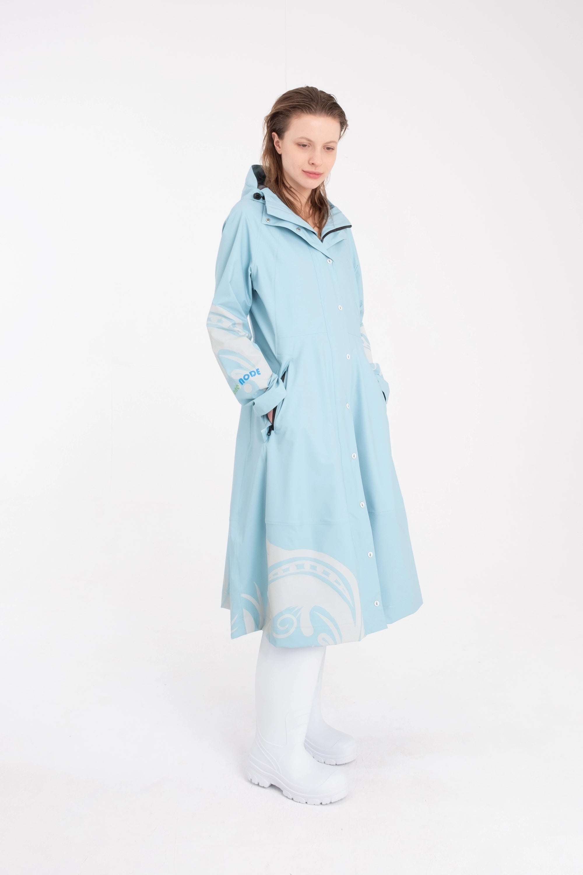 One NODE Scandinavian raincoat for women in sky blue with reflective details – a waterproof, lightweight, and eco-conscious jacket made with sustainable materials for enhanced visibility and style in Nordic weather.