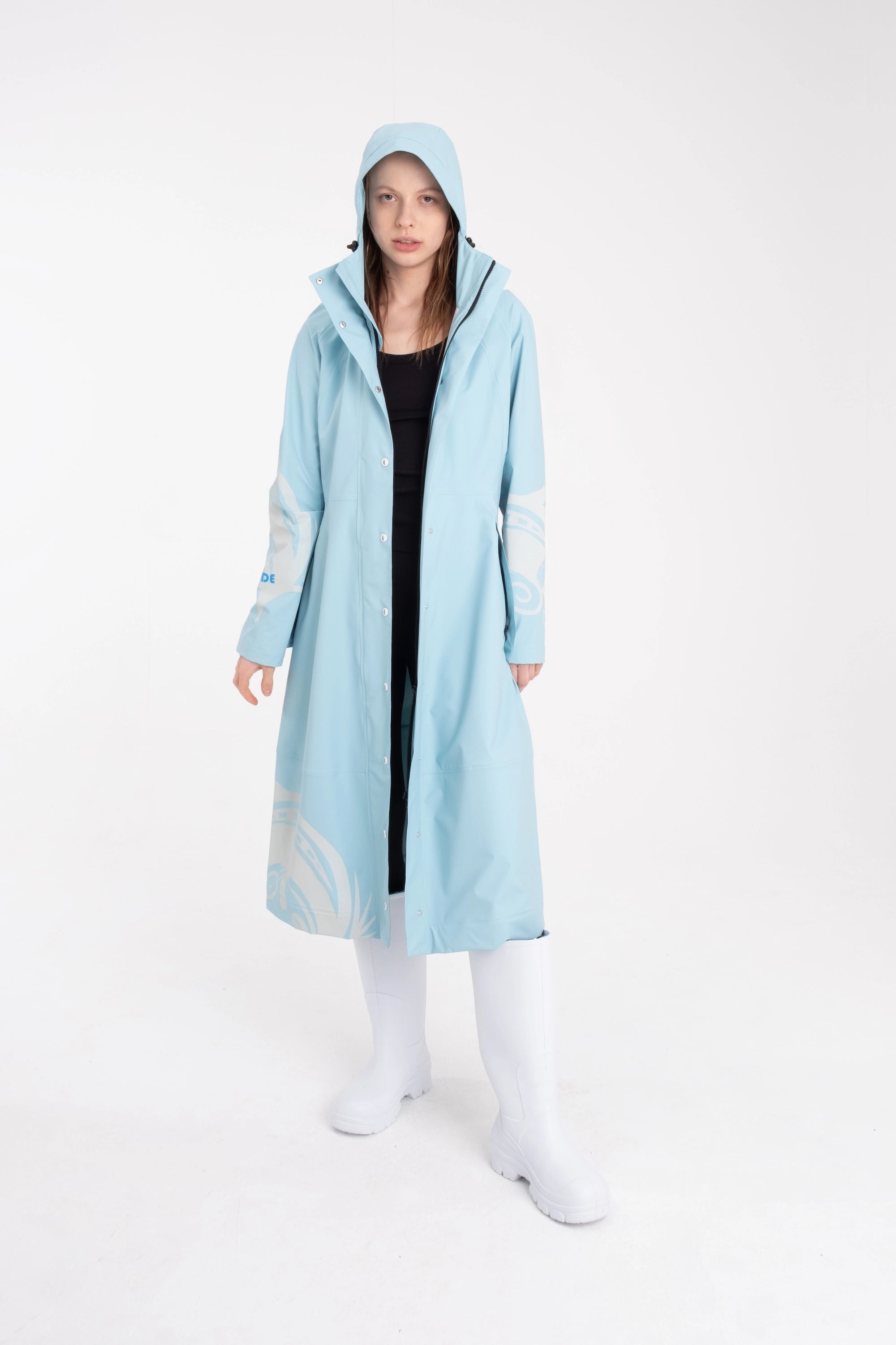 One NODE Scandinavian raincoat for women in sky blue with reflective details – a waterproof, lightweight, and eco-conscious jacket made with sustainable materials for enhanced visibility and style in Nordic weather.