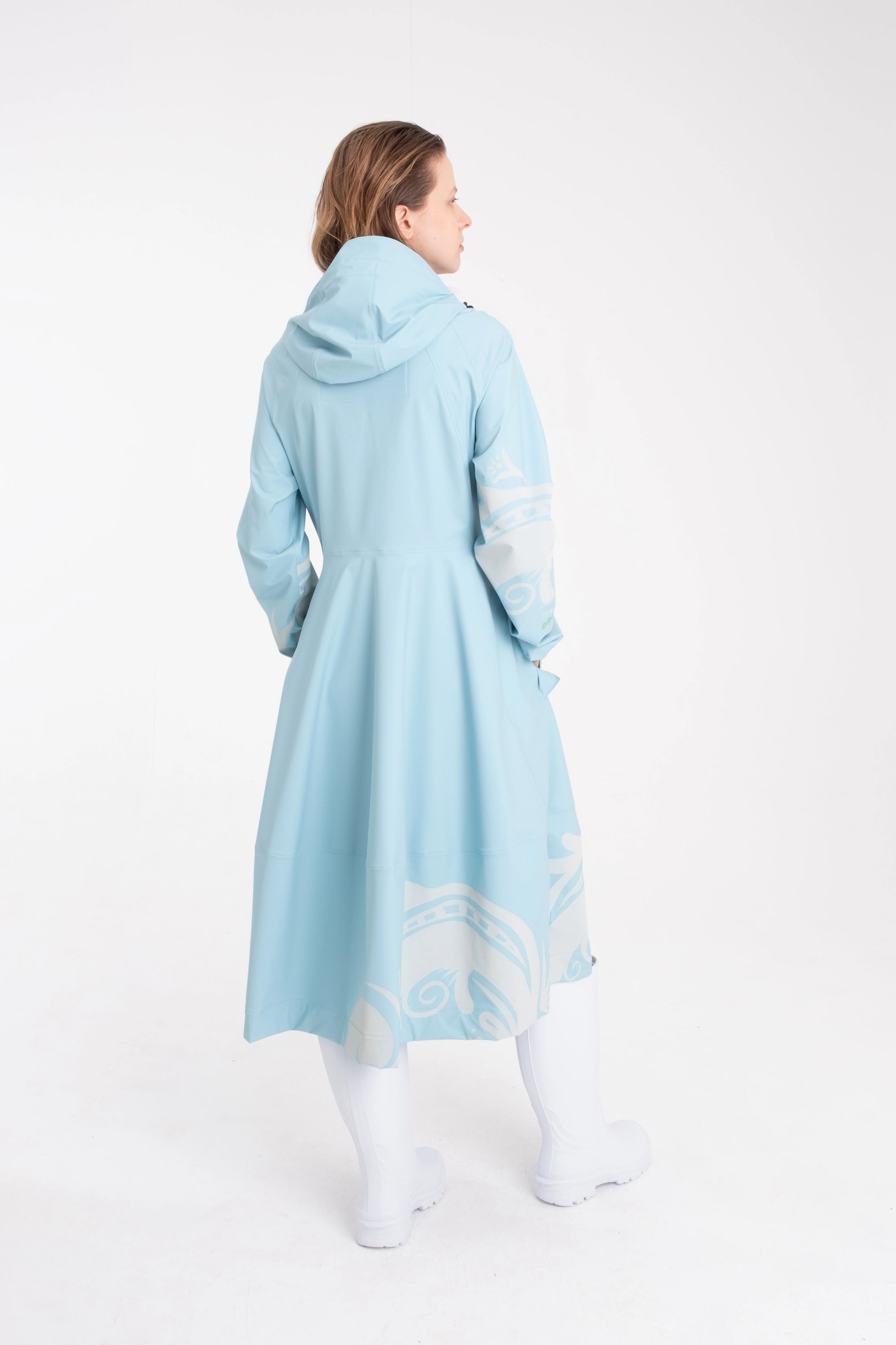 One NODE Scandinavian raincoat for women in sky blue with reflective details – a waterproof, lightweight, and eco-conscious jacket made with sustainable materials for enhanced visibility and style in Nordic weather.