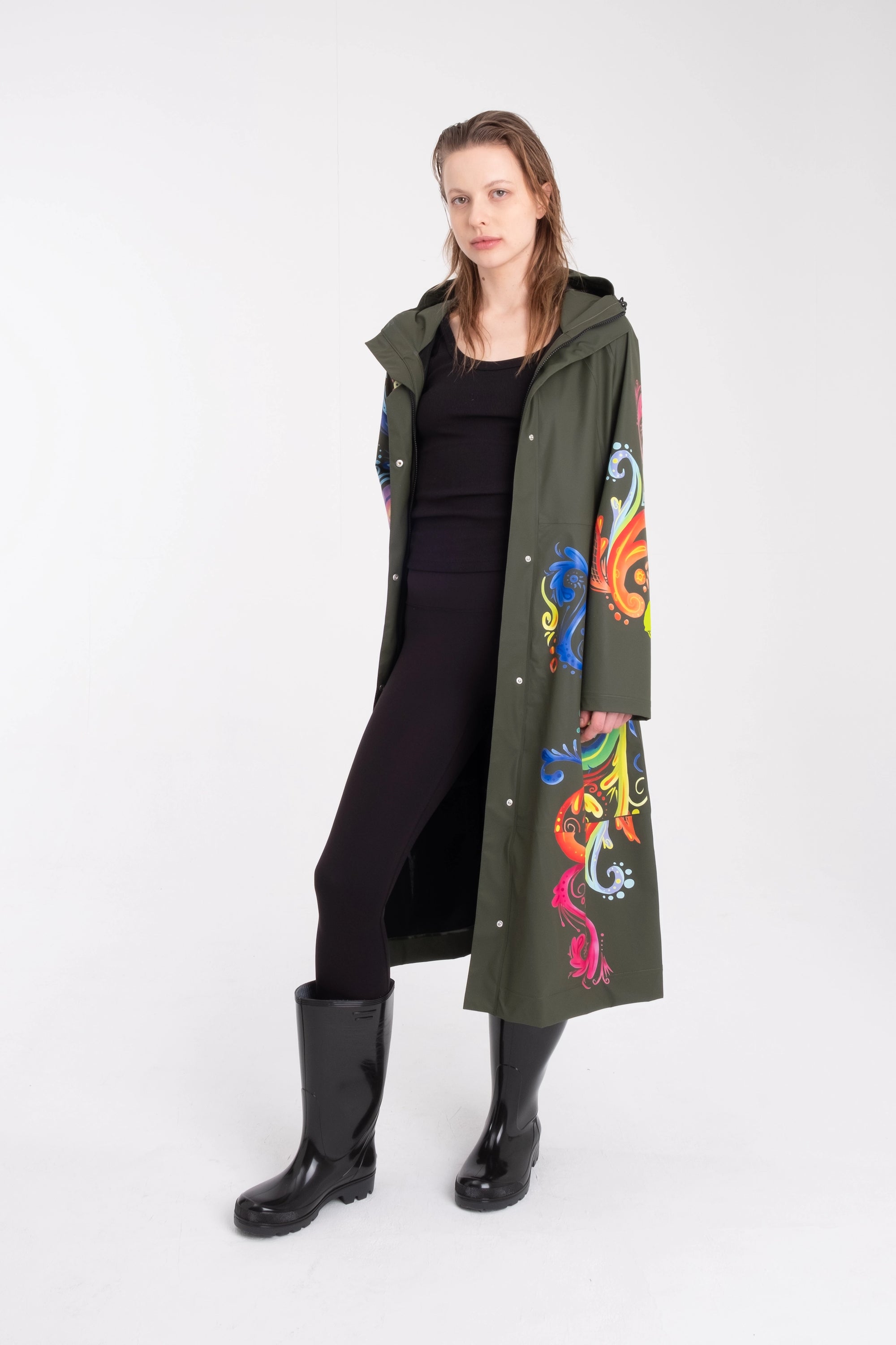 One NODE Scandinavian raincoat for women in olive green with intricate rosemaling pattern – a waterproof, lightweight, and eco-conscious jacket made with sustainable materials for Nordic weather.
