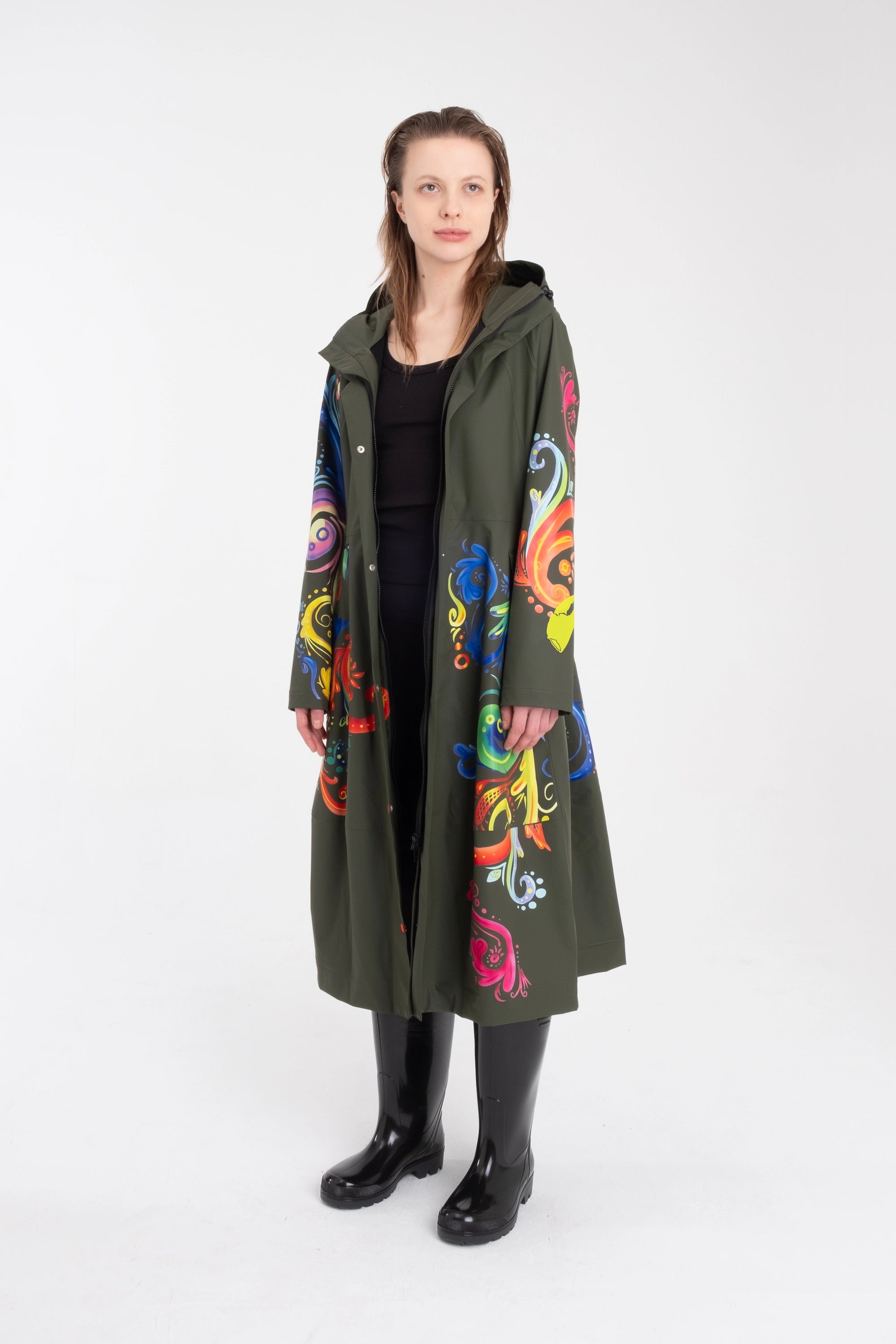 One NODE Scandinavian raincoat for women in olive green with intricate rosemaling pattern – a waterproof, lightweight, and eco-conscious jacket made with sustainable materials for Nordic weather.