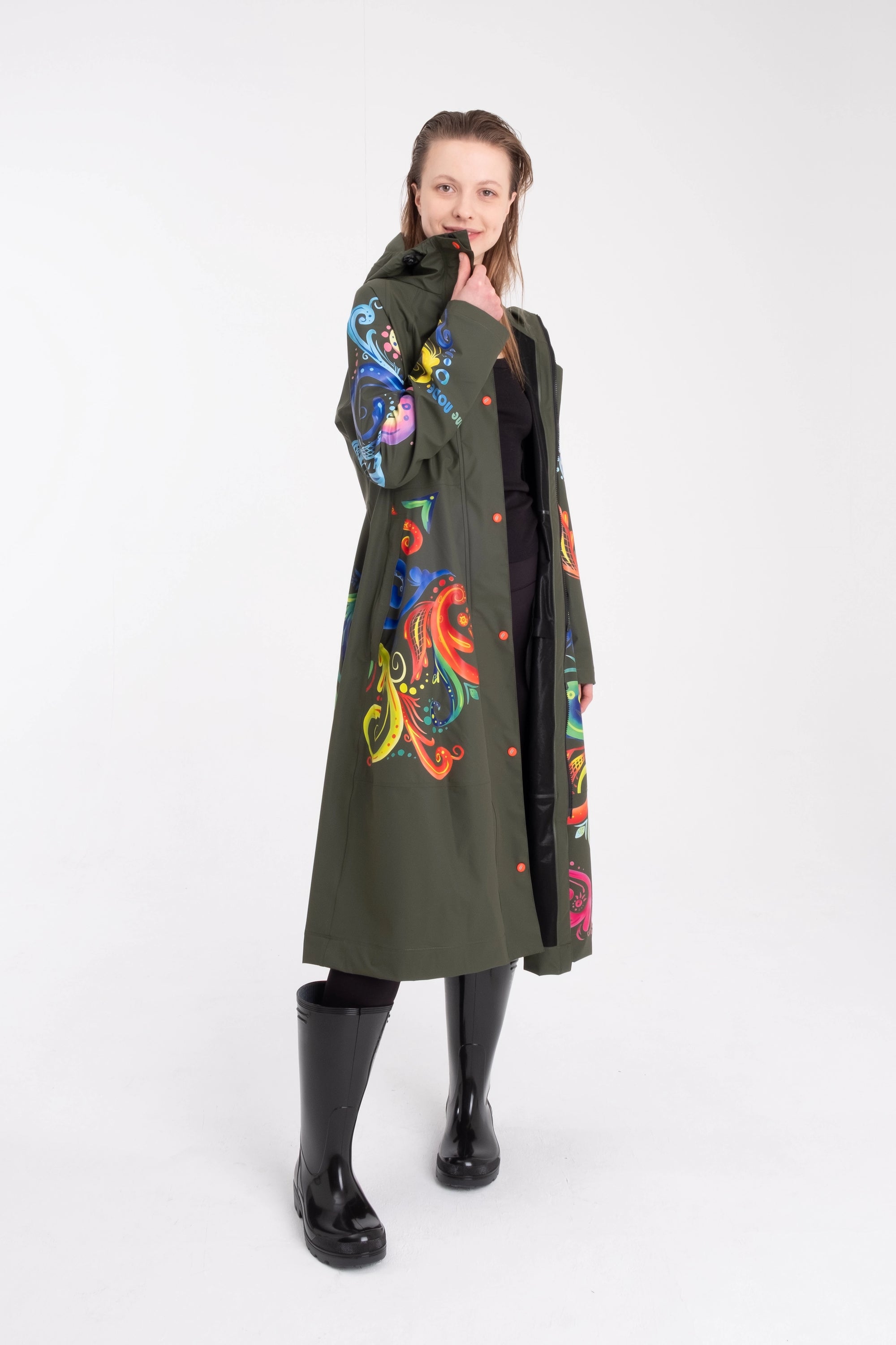 One NODE Scandinavian raincoat for women in olive green with intricate rosemaling pattern – a waterproof, lightweight, and eco-conscious jacket made with sustainable materials for Nordic weather.