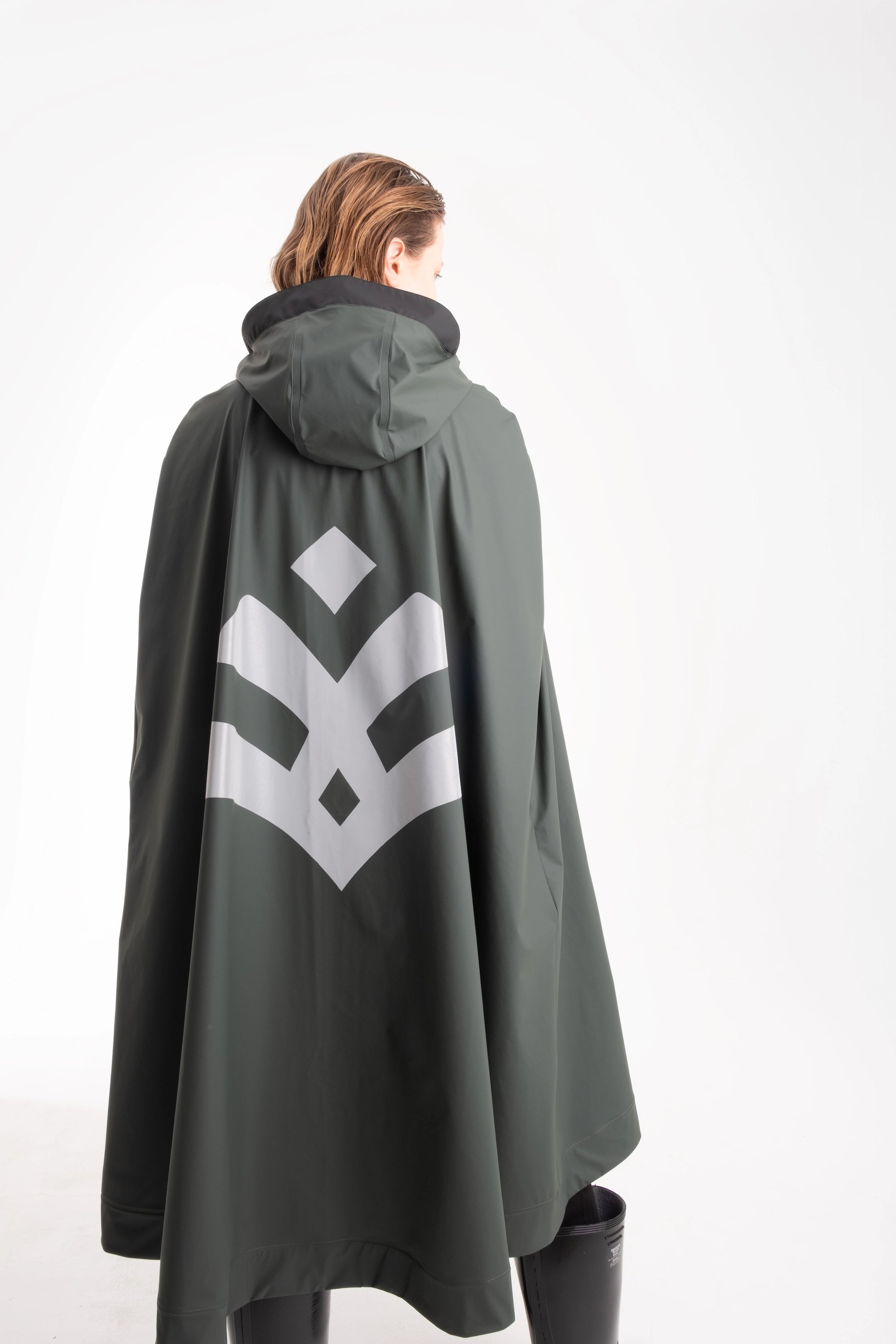 One NODE X Sagastad Cape Olive for women – a Scandinavian-designed waterproof and windproof cape with historical inspiration, crafted for all-weather protection and modern versatility.